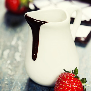 Delicious rich and thick chocolate sauce in a jug and assorted chocolates - food and drink