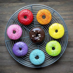 Colorful glazed donuts on a wire rack