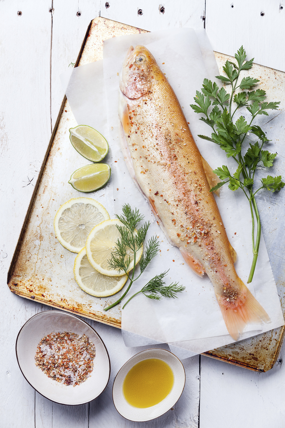 Raw fish golden trout with spices on wooden background